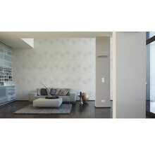 Wohnzimmer mit Sofa, Ottomanen, Teppich und gemusterter Tapete