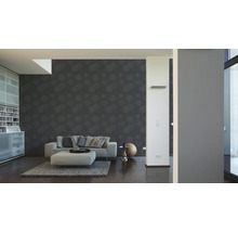 Wohnzimmer mit gemusterter Tapete, Sofa und Schrank