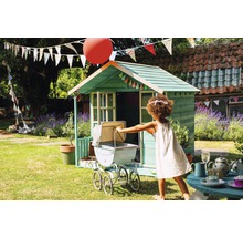 Kind spielt mit Puppenwagen vor Spielhaus im Garten.
