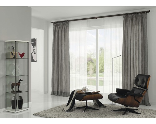 Wohnzimmer mit Vitrine, Vorhängen, Sessel und Teppich für eine gemütliche Atmosphäre