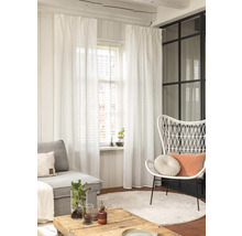 Wohnzimmer mit Sofa, Sessel, Tisch, Teppich und weißen Gardinen.