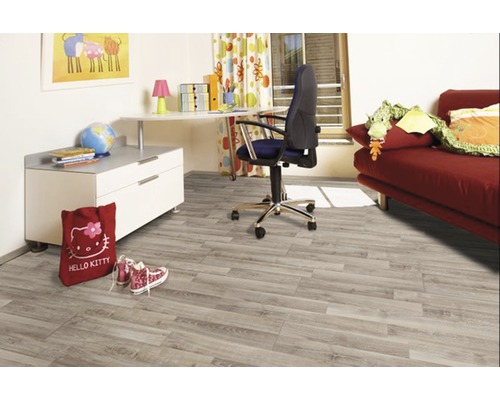 Kinderzimmer mit hellem Holzboden, Schreibtisch und rotem Sofa.