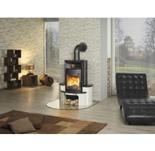 Wohnzimmer mit Kaminofen, Sessel und Holzlager