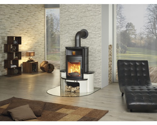 Wohnzimmer mit Kaminofen, Sessel und Holzlager