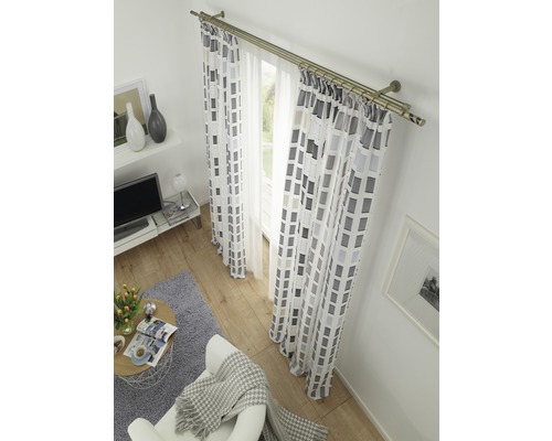 Wohnzimmer mit Fensterdekoration inklusive Gardinenstange und Vorhängen mit geometrischem Muster