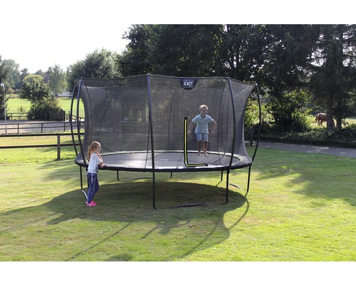 Trampolin mit Sicherheitsnetz im Garten mit spielenden Kindern