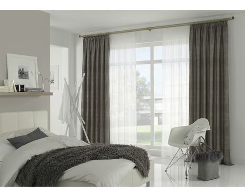 Helles Schlafzimmer mit Bett, Stuhl und Vorhängen an einer Gardinenstange vor dem Fenster.