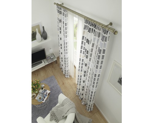 Wohnzimmer mit Gardinen und Vorhängen mit geometrischem Muster an einer Vorhangstange