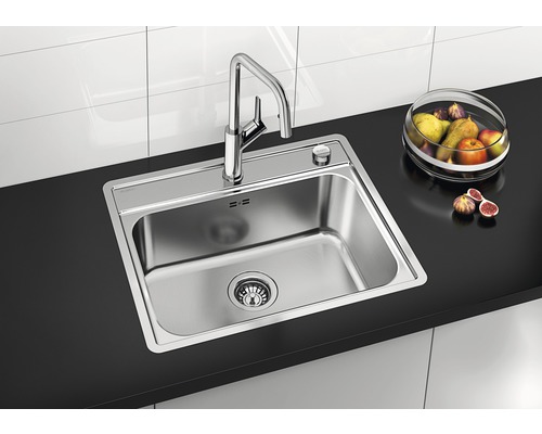 Edelstahlspüle mit Armatur auf einer Arbeitsplatte mit Obstschale