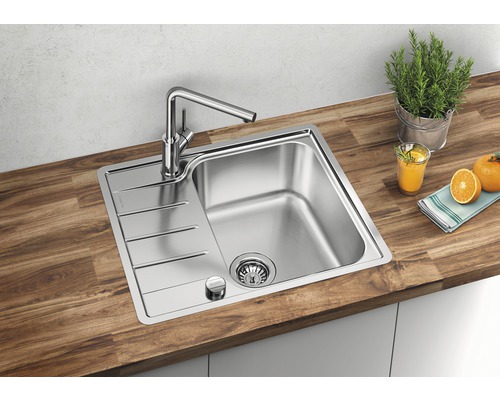 Edelstahlspüle mit Abtropffläche und Armatur auf einer Holzarbeitsplatte