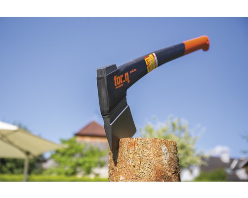 Axt von For Q steckt im Holzstamm.