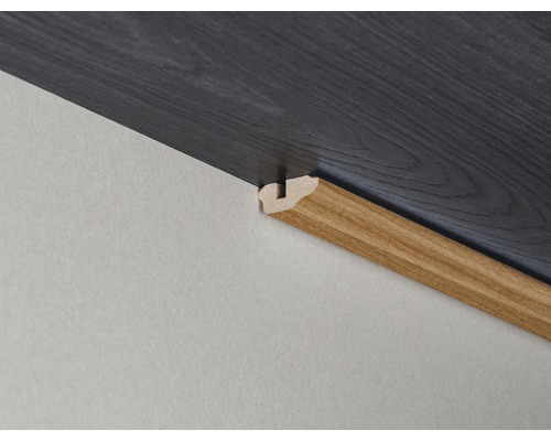 Verlegung von Laminatboden mit passender Holzsockelleiste an der Wand