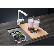 Küchenszene mit Spüle, Armatur, Schneidebrett und Getränken