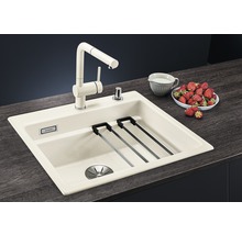 Küchenspüle mit Wasserhahn, Abtropfgestell und Spülmittelspender auf einer Küchentheke mit Erdbeeren und einem Krug Milch