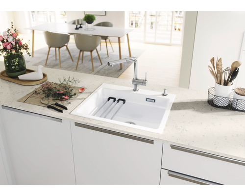 Küchenspüle mit Abtropfgestell, Armatur und Spülmittelspender in einer hellen Küche