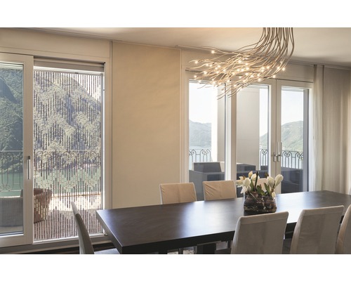 Esszimmer mit Esstisch, Stühlen und Bambusrollo vor dem Fenster mit Seeblick.