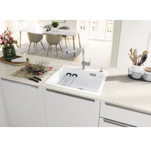 Küchenspüle mit Abtropfgestell und Einhebelmischer in einer hellen Küche.