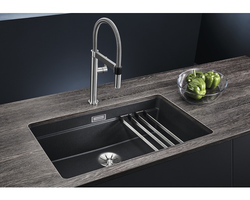 Spültisch mit Abtropfgitter, Armatur und Gemüsepaprika in einer Schüssel