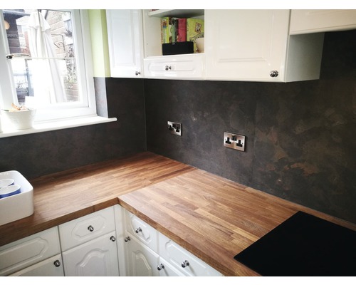 Küchenszene mit Arbeitsplatte aus Holz und dunkler Rückwand