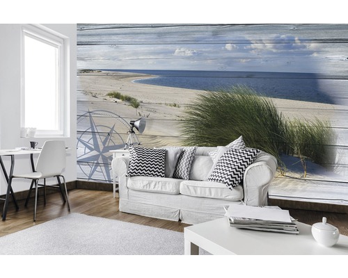 Wohnzimmer mit Fototapete, die einen Strand und eine Kompassrose zeigt