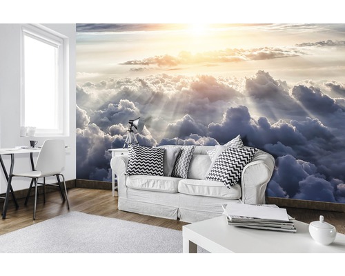 Wohnzimmer mit Fototapete, die den Himmel mit Wolken und Sonnenstrahlen zeigt.