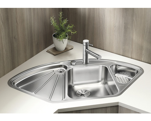 Eckspüle aus Edelstahl mit Abtropffläche und Armatur auf einer hellen Arbeitsplatte