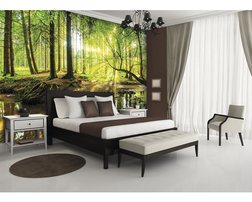 Schlafzimmer mit Waldtapete, Bett, Nachttischen und Sitzbank