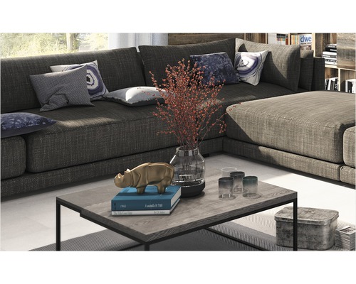 Wohnzimmerszene mit großem Ecksofa, Couchtisch mit Dekorationen und Kissen auf dem Sofa.