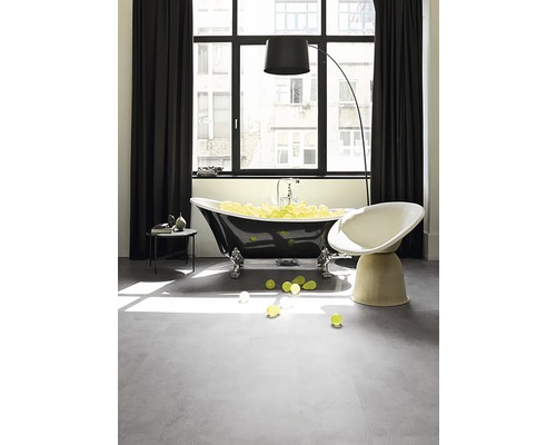 Modernes Badezimmer mit freistehender Badewanne, Sessel und Stehlampe vor einem Fenster.