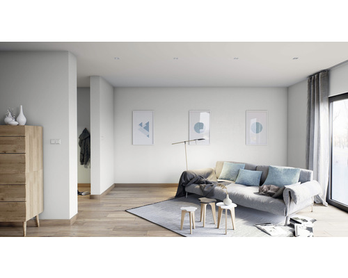 Heller Wohnraum mit Sofa, Teppich, Holzkommode und Wandbildern.