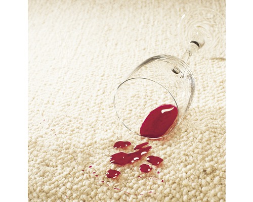 Rotweinfleck auf einem Teppich neben einem umgekippten Weinglas