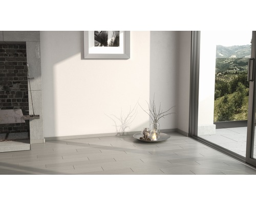 Heller Raum mit Fliesenboden, Kamin und Blick ins Grüne