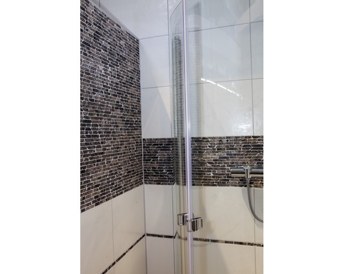 Detailansicht einer Duschkabine mit Glaswand und Fliesen im Badezimmer