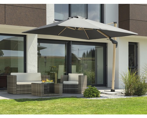 Gartenszene mit Ampelschirm und Rattansitzgruppe auf einer Terrasse