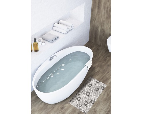 Badezimmer mit Badewanne, Handtüchern und gemusterter Badematte auf Holzboden