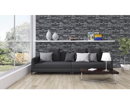 Wohnzimmer mit Backsteintapete, Sofa, Tisch und Dekoration für ein gemütliches Ambiente.