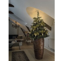 Weihnachtsbaum mit Kerzen in einem Wohnzimmer unter einer Dachschräge