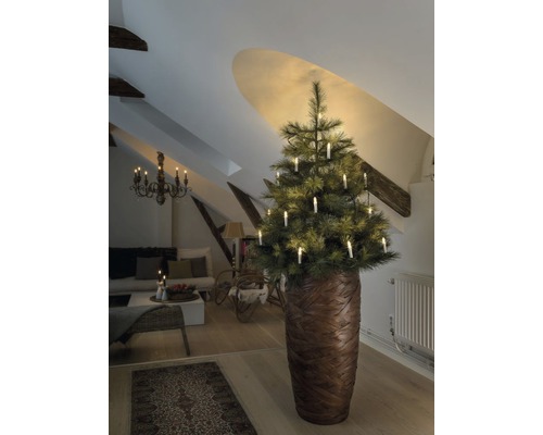 Weihnachtsbaum mit Kerzen in einem Wohnzimmer unter einer Dachschräge