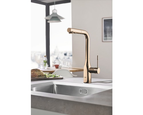 Küchenspüle mit goldfarbener Armatur in einer hellen Küche