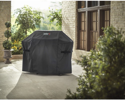 Abdeckhaube für Grill mit Weber Logo auf einer Terrasse