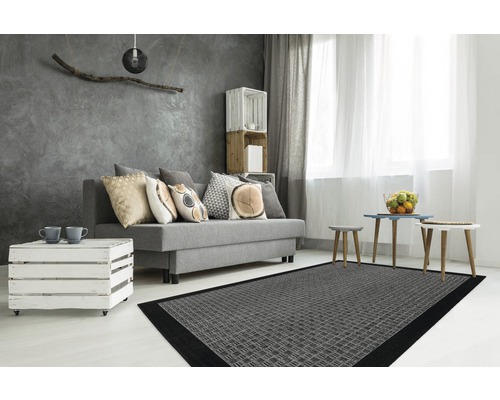 Wohnzimmer mit grauem Sofa, Kissen, Holztisch, grauem Teppich und Dekoration