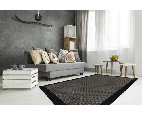 Modernes Wohnzimmer mit Sofa, Holzkiste als Tisch und gemustertem Teppich