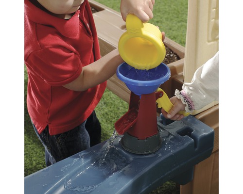 Kinder spielen mit einer Wasserrinne und einem Wasserfilter.