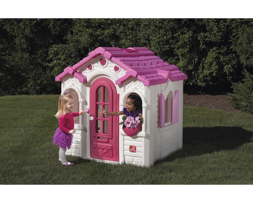 Spielhaus aus Kunststoff mit Tür und Fenstern im Garten, zwei spielende Kinder