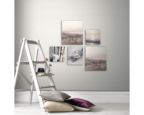 Dekorative Wand mit einer Auswahl an Leinwanddrucken, einer Staffelei, Kissen und Dekor