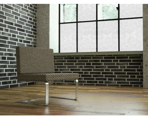 Szene mit einem Stuhl mit Metallbeinen vor einer Backsteinmauer und einem Fenster.