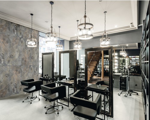 Innenraum eines Friseursalons mit Spiegeln, Stühlen und Beleuchtung