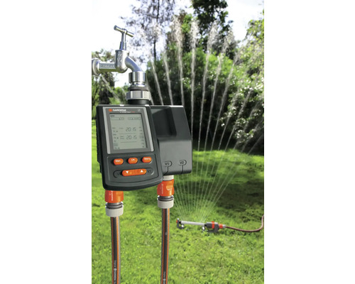 Gardena Bewässerungssteuerung mit angeschlossenem Gartenschlauch und Rasensprenger im Betrieb