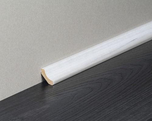 Weiß lackierte Fußleiste aus Holz am Boden und an der Wand