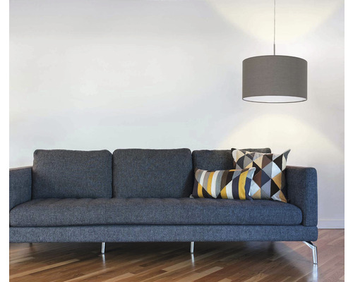 Wohnzimmer mit grauem Sofa, geometrischen Kissen und Hängelampe